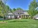 A welcoming single-story home with a well-maintained lawn, beautiful landscaping, and traditional architectural details at 2030 Gloucester St, Weddington, NC 28104