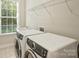 Bright laundry room with front load washer and dryer and a window at 2030 Gloucester St, Weddington, NC 28104