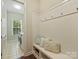 Functional mudroom with built-in bench seating, coat hooks, decorative pillows, and access to laundry area at 2030 Gloucester St, Weddington, NC 28104