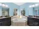 Bright bathroom featuring a corner soaking tub and dual vanities with granite countertops at 2146 Holden Sw Ave, Concord, NC 28025