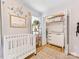 Cozy bedroom with closet, crib, changing table, and natural light streaming through the windows at 2214 Olde Chantilly Ct, Charlotte, NC 28205