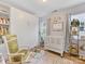 Bright Bedroom featuring a white crib, rocking chair, and built-in shelving with natural light at 2214 Olde Chantilly Ct, Charlotte, NC 28205