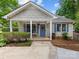 Charming home featuring a cozy covered porch, blue shutters, and a beautifully landscaped front yard at 2214 Olde Chantilly Ct, Charlotte, NC 28205