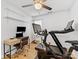 Bright home gym featuring exercise equipment and desk with computer, shelves, and a ceiling fan at 2214 Olde Chantilly Ct, Charlotte, NC 28205