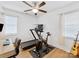 Bright home gym featuring exercise equipment and desk with computer, with 2 windows and ceiling fan at 2214 Olde Chantilly Ct, Charlotte, NC 28205