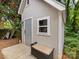 A well-maintained shed with neutral siding, a window, a door, and an outdoor bench, nestled in a lush, green yard at 2214 Olde Chantilly Ct, Charlotte, NC 28205