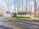 View of home and detached two-car garage, and gravel driveway, surrounded by mature trees at 300 Boyd Rd, Clover, SC 29710