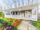 Charming home exterior boasts a covered front porch with stone pathway and verdant landscaping at 300 Boyd Rd, Clover, SC 29710