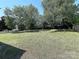 Wide open backyard featuring large shade trees and a grass lawn at 3007 Walsingham Ct, Matthews, NC 28105