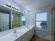 Well-lit bathroom featuring a double sink vanity and shower with glass door at 3007 Walsingham Ct, Matthews, NC 28105
