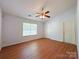 Bright bedroom with wood-look flooring, a ceiling fan, and plenty of natural light at 3007 Walsingham Ct, Matthews, NC 28105