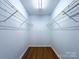 Walk-in closet with built-in shelving and wood-look flooring at 3007 Walsingham Ct, Matthews, NC 28105