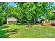 Lush backyard with a fire pit, storage shed, and wooden deck, ideal for outdoor entertaining and relaxing at 302 Griffith Rd, Monroe, NC 28112