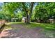 Backyard featuring mature trees, a storage shed, and a wooden deck, offering a serene outdoor environment at 302 Griffith Rd, Monroe, NC 28112