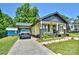 The front exterior reveals a well-manicured lawn, driveway, and stylish yellow home with a covered carport at 302 Griffith Rd, Monroe, NC 28112