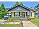 Charming yellow home featuring a welcoming front porch, gray accents, and well-maintained landscaping at 302 Griffith Rd, Monroe, NC 28112