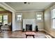 Bright living room featuring a charming brick fireplace, hardwood floors, and plenty of natural light at 302 Griffith Rd, Monroe, NC 28112