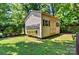Backyard shed with painted wood and a gable roof, set among trees and grass, ideal for storage or a workshop at 302 Griffith Rd, Monroe, NC 28112