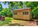 Well-built backyard shed with a pair of doors, offering ample storage and blending seamlessly with the lush greenery at 302 Griffith Rd, Monroe, NC 28112