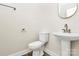 Compact powder room featuring a pedestal sink, toilet, and decorative mirror in a neutral color scheme at 3204 Leah Elizabeth Ln, Monroe, NC 28110