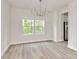 Bright dining room with laminate flooring, modern chandelier, large windows with scenic outdoor view at 3204 Leah Elizabeth Ln, Monroe, NC 28110