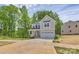Two-story home with a two-car garage, a front porch, and surrounded by mature trees at 3204 Leah Elizabeth Ln, Monroe, NC 28110