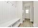Hallway mudroom featuring a white paneled bench with storage, neutral walls, and laminate flooring at 3204 Leah Elizabeth Ln, Monroe, NC 28110