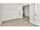 Empty room with laminate flooring, neutral walls, glass-paneled door, with hallway and staircase view at 3204 Leah Elizabeth Ln, Monroe, NC 28110