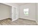 Empty room with laminate flooring, neutral walls, window with blinds, and a glass-paneled door with hardware at 3204 Leah Elizabeth Ln, Monroe, NC 28110