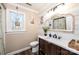 Bright bathroom featuring shiplap accent wall, a modern vanity with a vessel sink, and a window with hanging plants at 3765 11Th Ne St, Hickory, NC 28601
