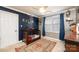 Lovely Bedroom with a navy accent wall, featuring a wooden crib and a colorful rug, creating a cozy and inviting space at 3765 11Th Ne St, Hickory, NC 28601