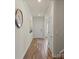Hallway with hardwood floors, white trim, and neutral-colored walls, leading towards a living space at 4104 Armstrong Farm Dr, Belmont, NC 28012