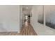 Hallway with hardwood floors, white trim, and neutral-colored walls, leading towards a living space at 4104 Armstrong Farm Dr, Belmont, NC 28012