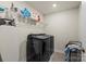 Laundry room with black washer and dryer, ironing board, and shelving at 4104 Armstrong Farm Dr, Belmont, NC 28012