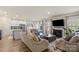 Open-concept living room features hardwood floors, fireplace, large windows, and comfortable seating at 4104 Armstrong Farm Dr, Belmont, NC 28012