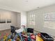 Brightly lit room with hardwood flooring, two windows and containing a number of toys and baby accessories at 4104 Armstrong Farm Dr, Belmont, NC 28012