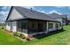 A screened in porch with a table and chairs, with green grass and landscaping surrounding at 4210 Holly Ne Cir, Conover, NC 28613