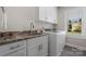 Laundry room featuring modern white cabinets, granite countertop, sink, and a washer and dryer at 4210 Holly Ne Cir, Conover, NC 28613