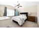 Cozy bedroom showcasing a comfortable bed, ceiling fan, and a large window for natural light at 4644 Craigmoss Ln, Charlotte, NC 28278