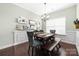 Elegant dining room with modern lighting, wainscoting, and dark wood flooring at 4644 Craigmoss Ln, Charlotte, NC 28278