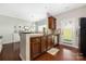 Open kitchen with dark countertops, stainless steel appliances and hardwood floors at 4644 Craigmoss Ln, Charlotte, NC 28278