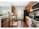 Bright kitchen features dark wood cabinets, stainless steel appliances and hardwood floors at 4644 Craigmoss Ln, Charlotte, NC 28278
