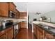 Modern kitchen featuring stainless steel appliances, dark wood cabinets, and hardwood floors at 4644 Craigmoss Ln, Charlotte, NC 28278