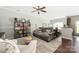 Comfortable living room with decorative pillows on the sofa, a ceiling fan and a bookcase filled with colorful books at 4644 Craigmoss Ln, Charlotte, NC 28278