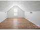 A well-lit attic bedroom features wood flooring and white walls at 5291 Moonlight Sw Trl, Concord, NC 28025