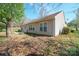 Back of home with covered patio, siding, and mature trees at 5291 Moonlight Sw Trl, Concord, NC 28025