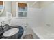 A well-lit bathroom features a sink with dark marble counter, white tile, and a bathtub with shower at 5323 Hilltop Cir, Charlotte, NC 28269