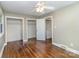 Bright bedroom with hardwood floors, ceiling fan, and ample closet space for optimal storage at 5323 Hilltop Cir, Charlotte, NC 28269