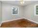 This cozy bedroom is illuminated by natural light from two windows, enhanced with beautiful hardwood flooring at 5323 Hilltop Cir, Charlotte, NC 28269