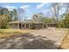 Spacious driveway leading to a charming one-story home with a detached carport and blossoming trees at 5323 Hilltop Cir, Charlotte, NC 28269